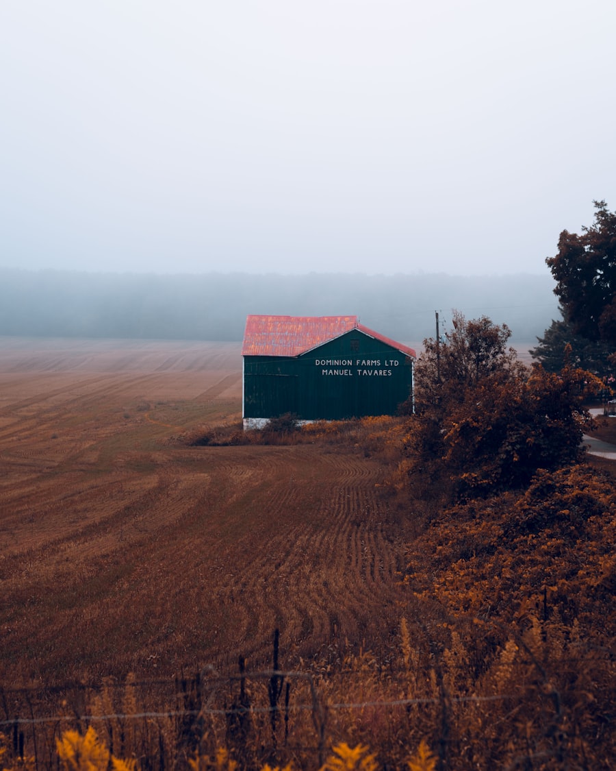 A red barn in an open field under a wide sky
